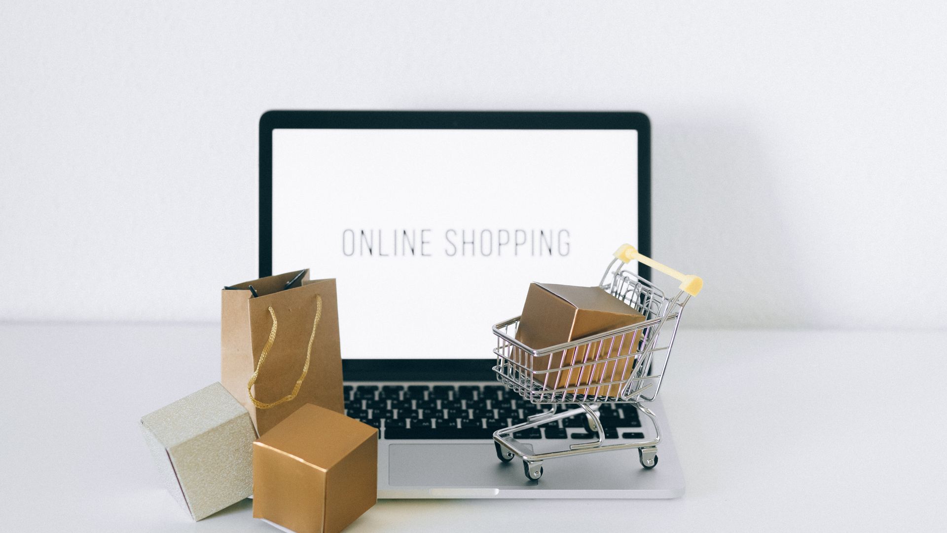 E-commerce website setup with a laptop, shopping basket and delivery boxes